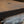 Load image into Gallery viewer, A side view of the wooden top on a refurbished metal hospital cart, with a focus on a metal inlay.