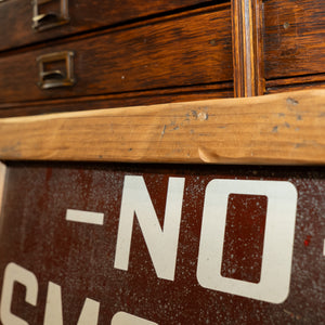A close up image of the wooden frame on a vintage "No Smoking" sign.