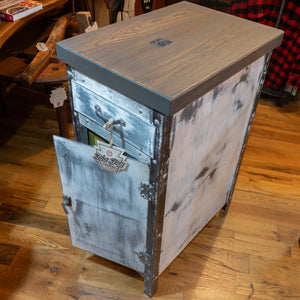 A unique white metal table with a grey top showcased in a furniture store.